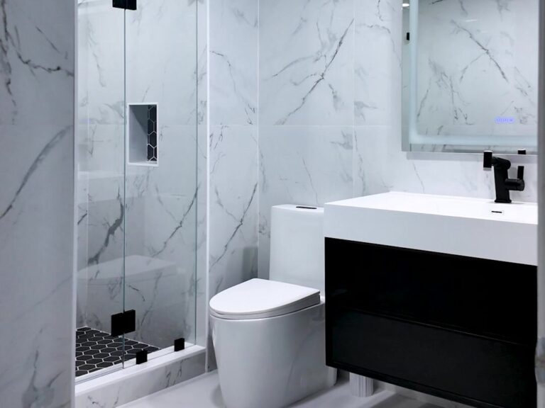 Walk-in shower with marble-look tile, black fixtures and floating vanity by Dreamery