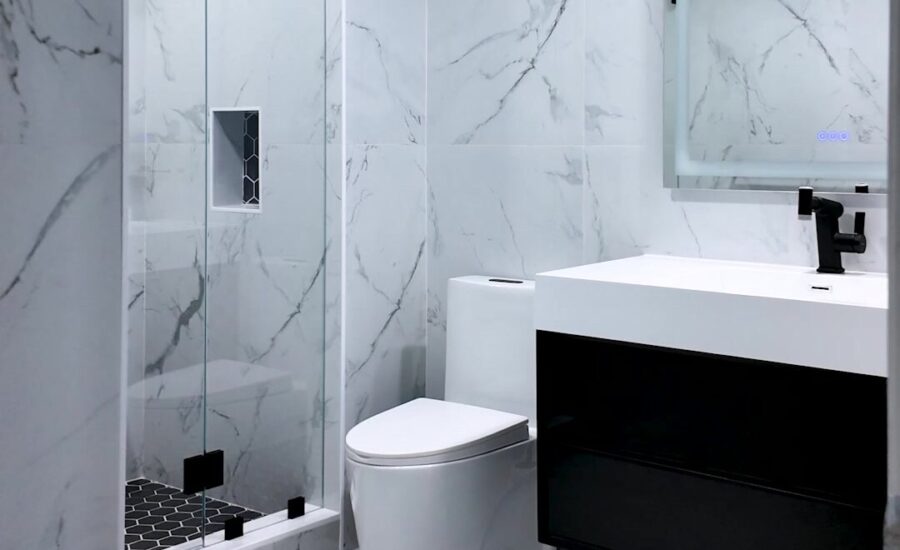 Walk-in shower with marble-look tile, black fixtures and floating vanity by Dreamery